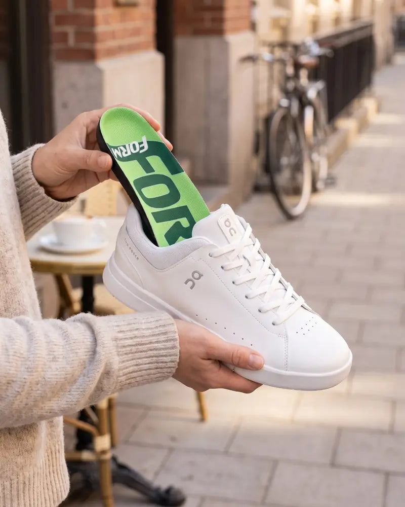 All Purpose insole going into a white sneaker on a city street