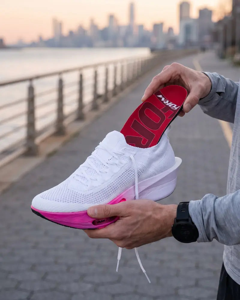 Narrow insole going into a running shoe on a waterfront path